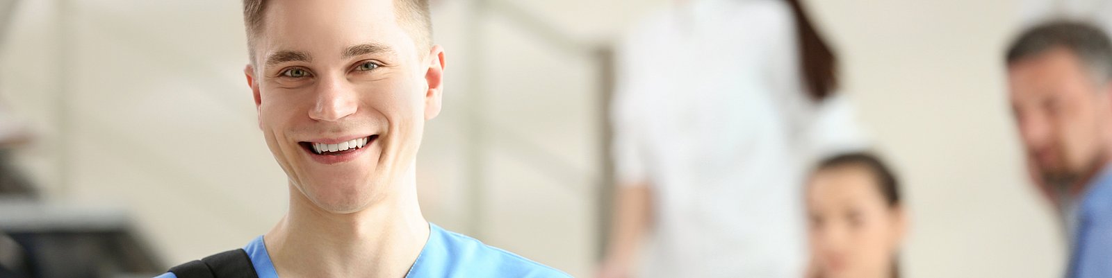 Junge männliche Pflegekraft mit Rucksack über der Schulter