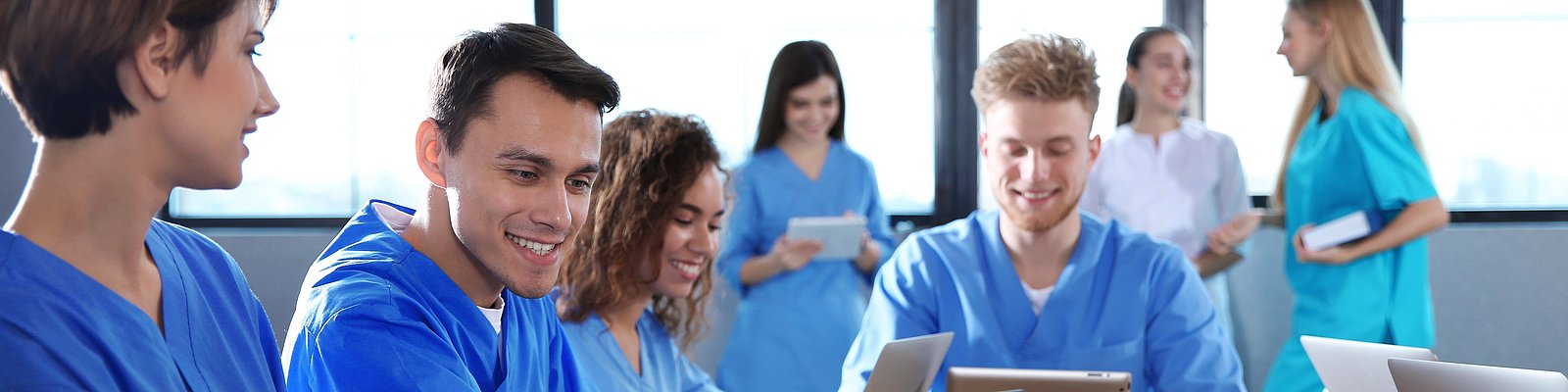 Pflegestudentinnen und -studenten in einem Seminarraum